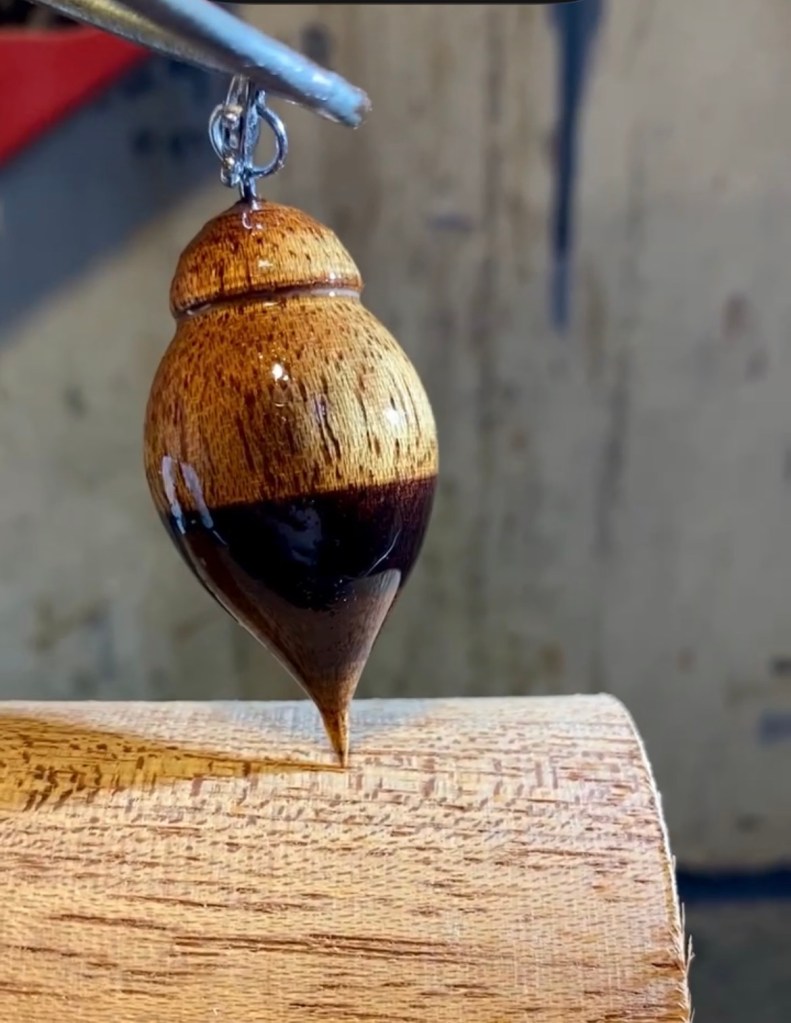 Pendentif en bois tourné bicolore, clair et sombre, en forme de larme allongée