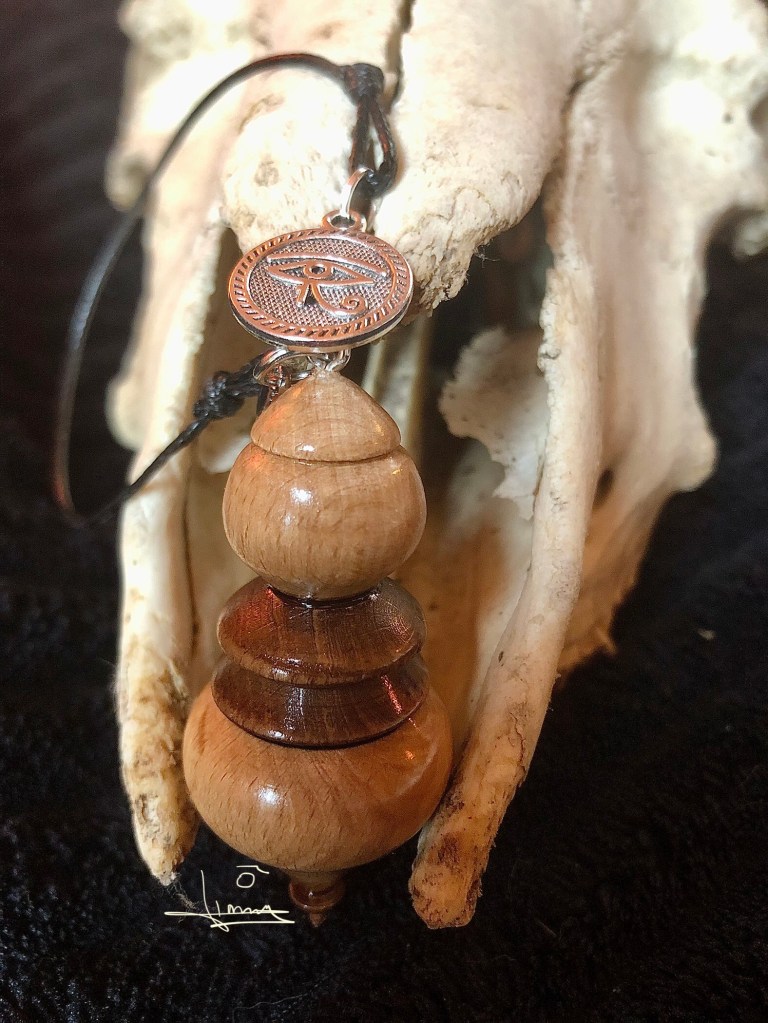 Pendule de radiesthésie en bois tourné avec Œil d’Horus sur crâne animal